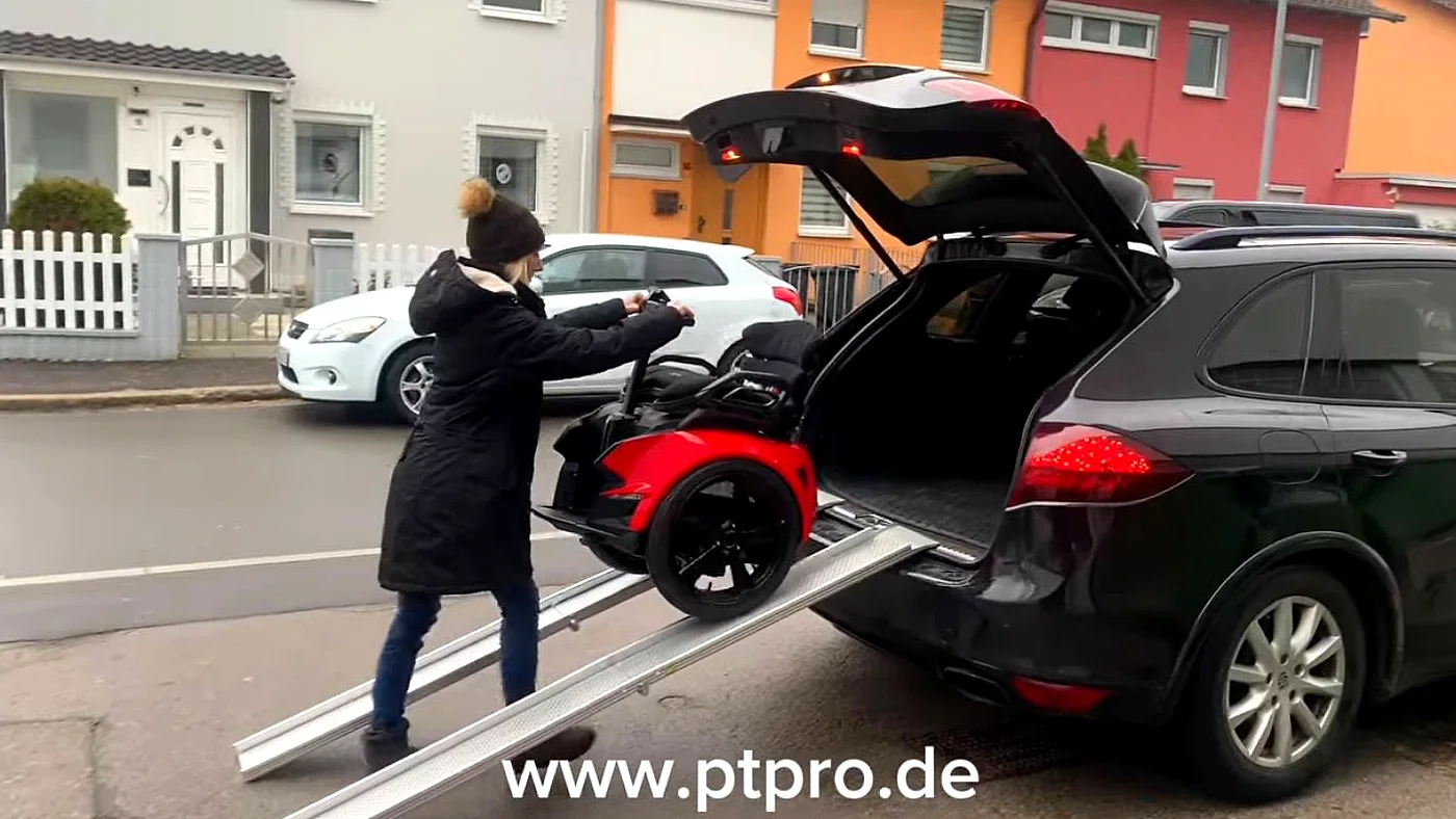 Genny Zero Balance-Rollstuhl wird über zwei Auffahrrampen in den Kofferraum eines SUV verladen