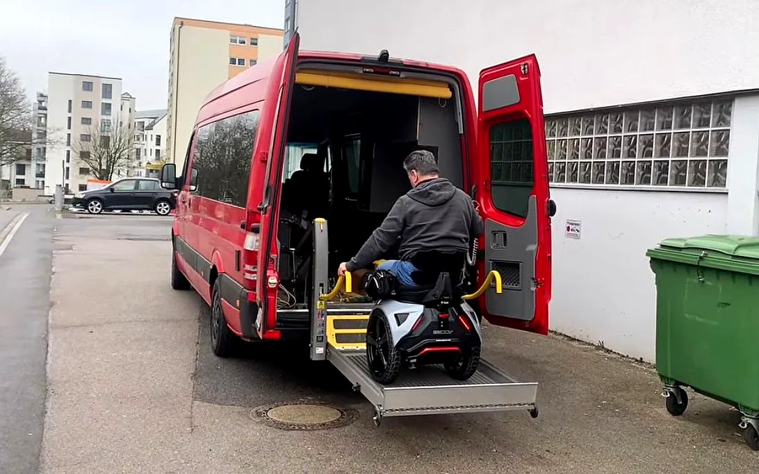 Genny Zero wird über einen Plattformlift in einen Van eingeladen