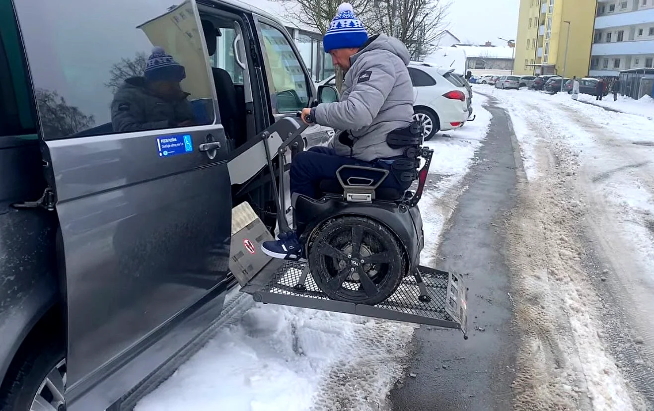 Fahrer fährt mit der Genny Zero selbstständig auf einen Plattformlift an einem Van