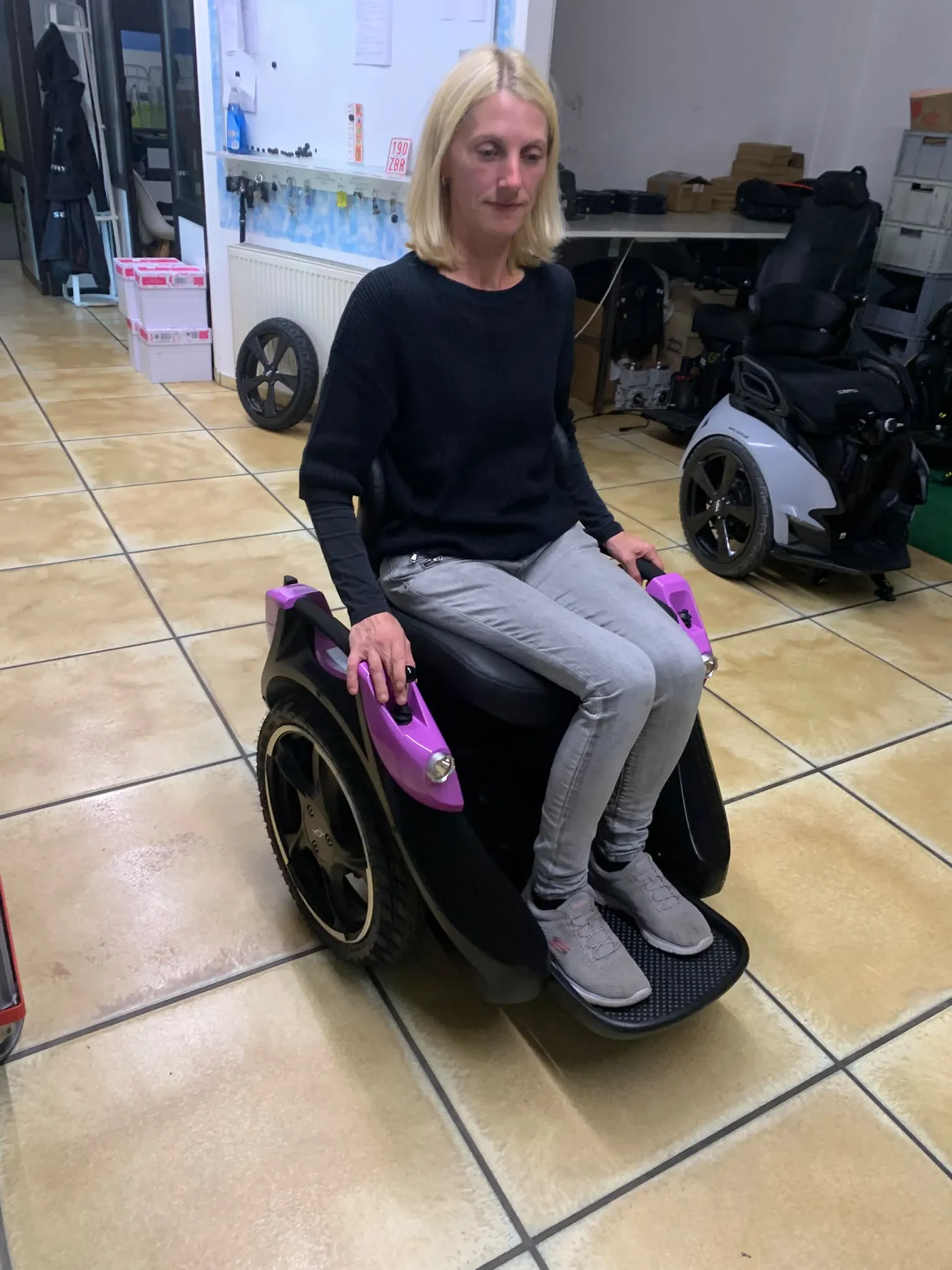 PT-Pro-Mitarbeiterin sitzt auf einem fertig aufgebauten Omeo im Showroom