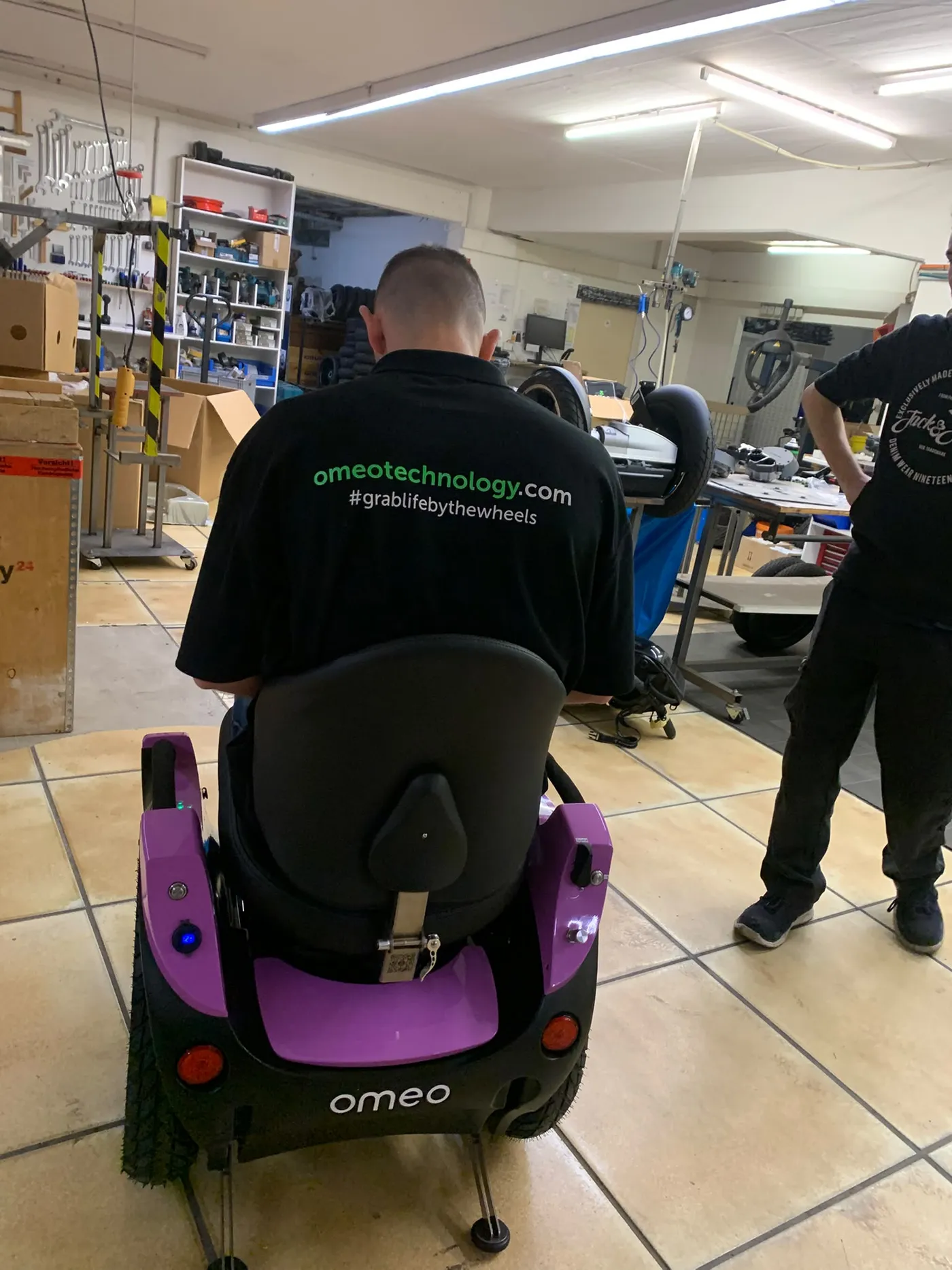 Omeo-Techniker sitzt testweise auf einem frisch aufgebauten Omeo in der PT-Pro-Werkstatt